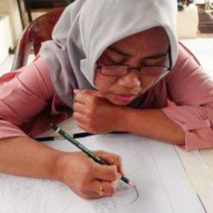 Ibu Mariah drawing out their final design with a pencil.